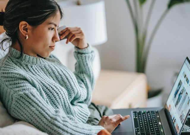 Girl sitting on couch with laptop.